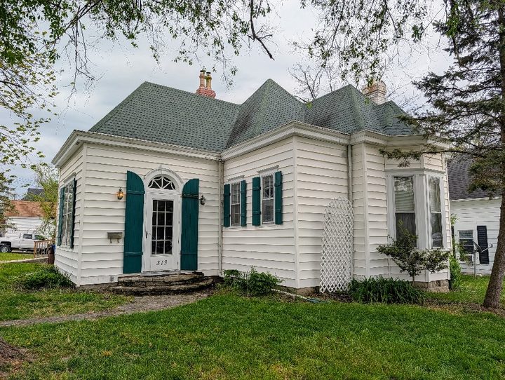 Older Winchester home with a steep roof and green shutters